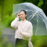 「雨の日に悪化する頭痛や肩こりに悩む女性のイメージ」