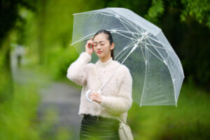 「雨の日に悪化する頭痛や肩こりに悩む女性のイメージ」