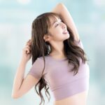 猫背・巻き肩・反り腰に悩む女性がTシャツ姿で姿勢をチェックしている様子