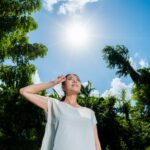 「冷たいおしぼりで首を冷やす女性」