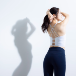 反り腰姿勢で立つ女性。骨盤が前傾し腰が大きく反っている様子