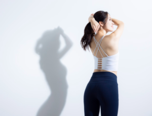 反り腰姿勢で立つ女性。骨盤が前傾し腰が大きく反っている様子