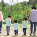 お父さん、お母さん、子どもが手をつないで歩く温かい後ろ姿