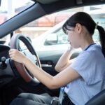 交通事故で追突された瞬間、首が大きく後方へ揺さぶられる運転手。むちうちの原因となる衝撃をイメージした交通事故治療のイメージ画像。