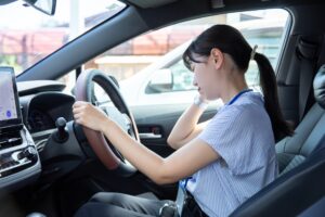 交通事故で追突された瞬間、首が大きく後方へ揺さぶられる運転手。むちうちの原因となる衝撃をイメージした交通事故治療のイメージ画像。