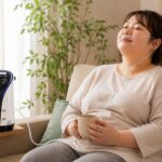ソファでリラックスしながら鼻から水素吸入を受ける40代女性。健康維持やHbA1cが気になる方のセルフケアをイメージした写真。